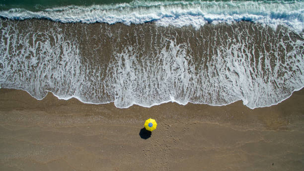 istock AERIAL: sunbathing on beach. No people only umbrella 941411168