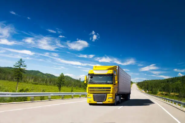 Photo of Yellow truck on a road in summer