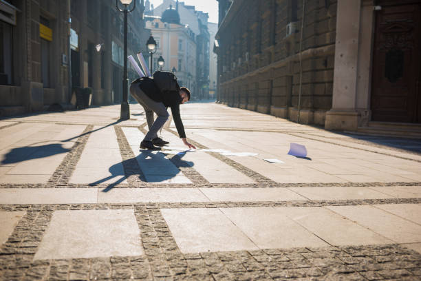 istock Papers spilling from businessman folder while he is rushing to the office 941412446
