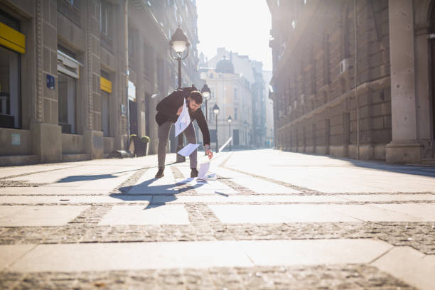 istock Papers spilling from businessman folder while he is rushing to the office, talking on a mobile phone 941412560