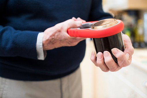 Close Up Of Senior Man Taking Lid Off Jar With Kitchen Aid