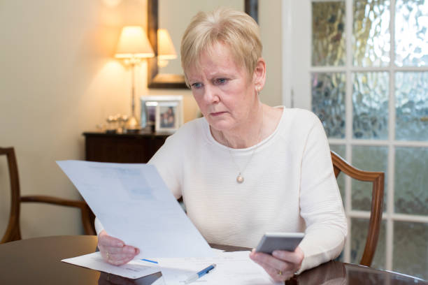 Concerned Senior Woman Reviewing Domestic Finances Concerned Senior Woman Reviewing Domestic Finances cost of living stock pictures, royalty-free photos & images