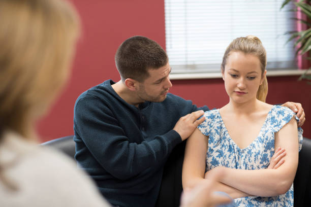 istock Couple Talking With Counselor As Man Comforts Woman 941416650