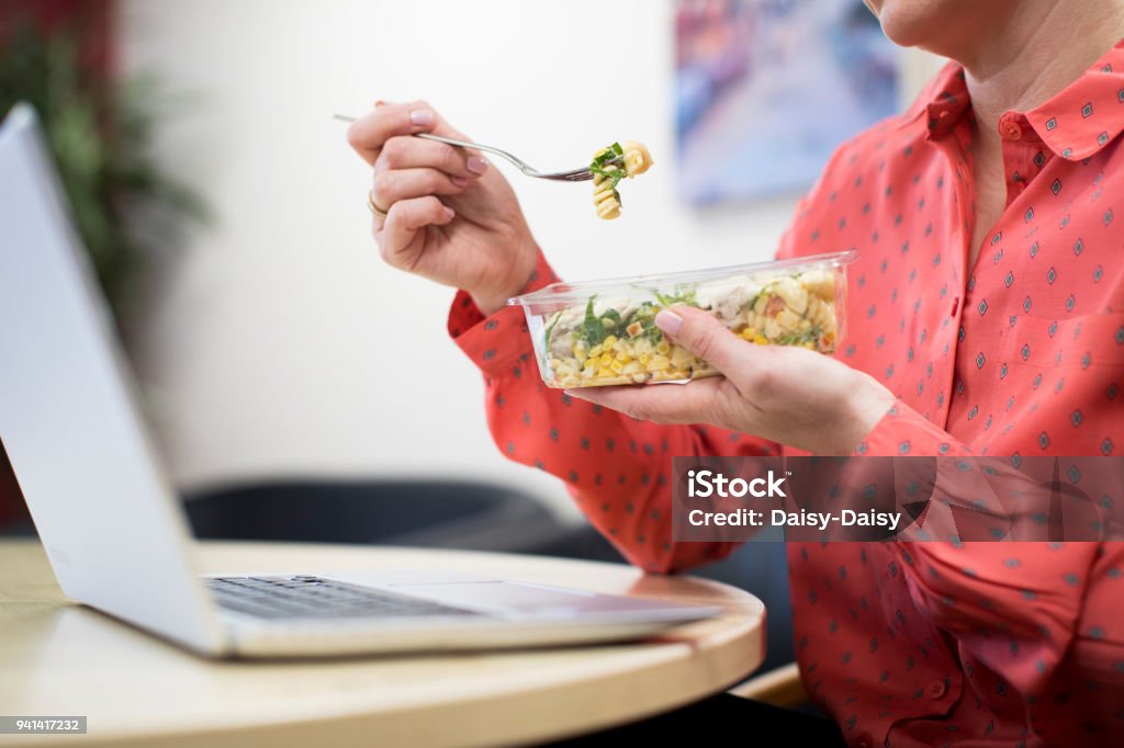 Travailleuse au bureau déjeunant pâtes sain au bureau - Photo de Déjeuner libre de droits