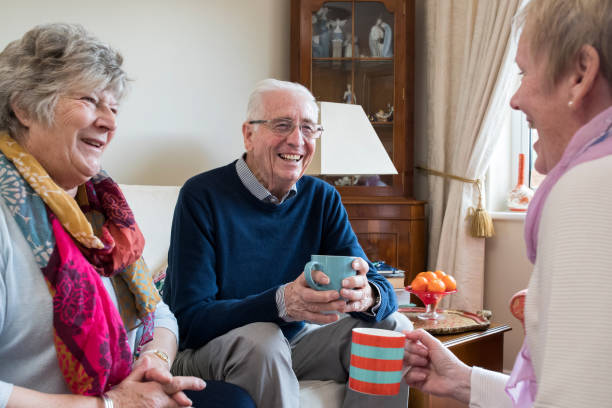 gruppo di amici anziani che si incontrano a casa per un caffè - discussion couple senior adult inside of foto e immagini stock