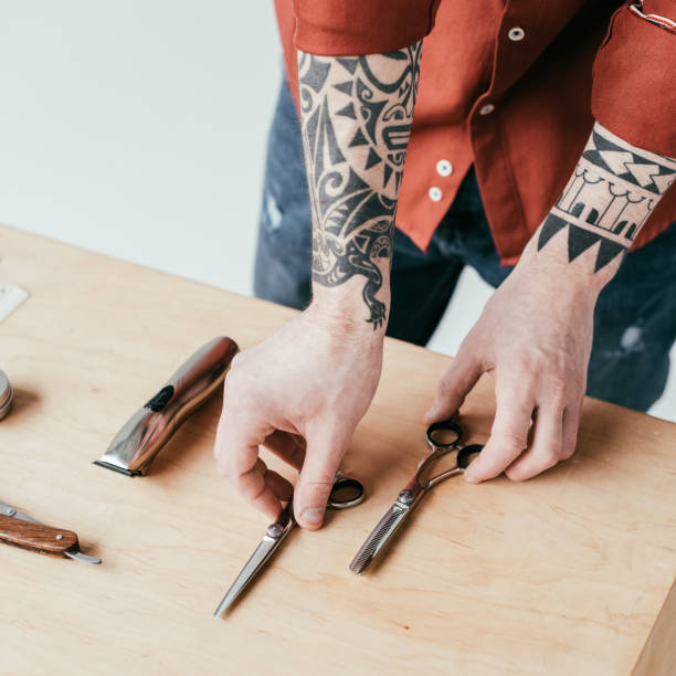 istock cropped image of tattooed barber taking scissors from table isolated on white 941420758