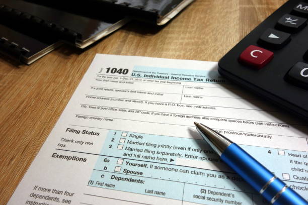 istock Form 1040, pen and calculator 941423860