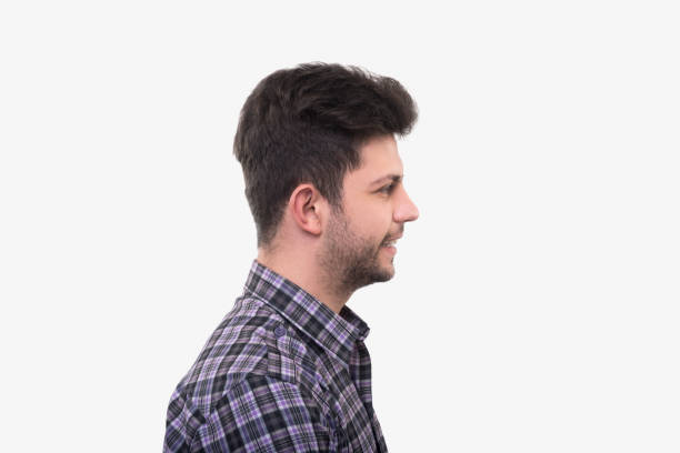 istock Profile view of smiling young man looking away over white background 941424796