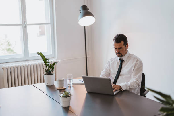 istock Mature hispanic man using laptop on desk at office. 941425036