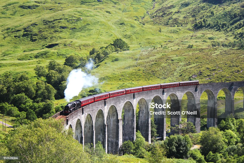 Glenfinnan Viaduct & Steam Train The Jacobite steak train passing over the Glenfinnan Viaduct in the Scottish Highlands. Glenfinnan Stock Photo