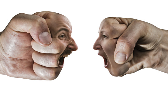Two fists with a male and female face collide with each other on isolated, white background. Concept of confrontation, competition, family quarrel etc.