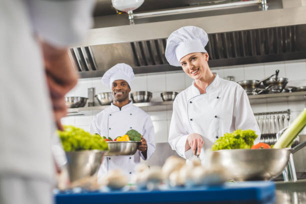 istock smiling multicultural chefs preparing food at restaurant kitchen and looking at camera 941436566