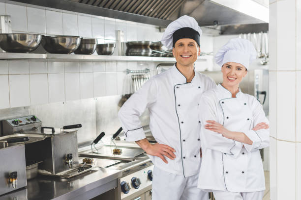 istock smiling male and female chefs looking at camera at restaurant kitchen 941439008