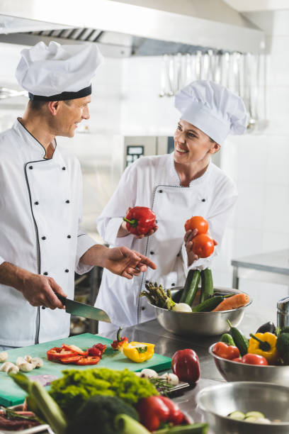 istock smiling chefs cooking and looking at each other at restaurant kitchen 941439284