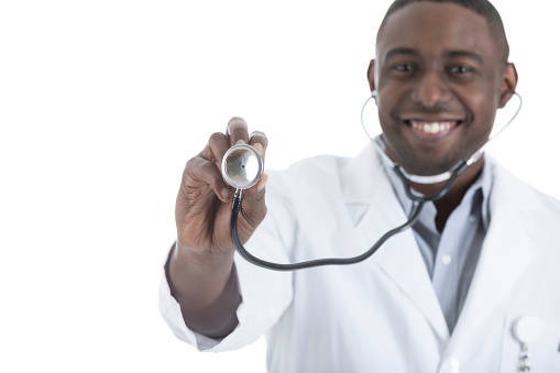 Handsome mid adult African American doctor holds out a stethoscope.