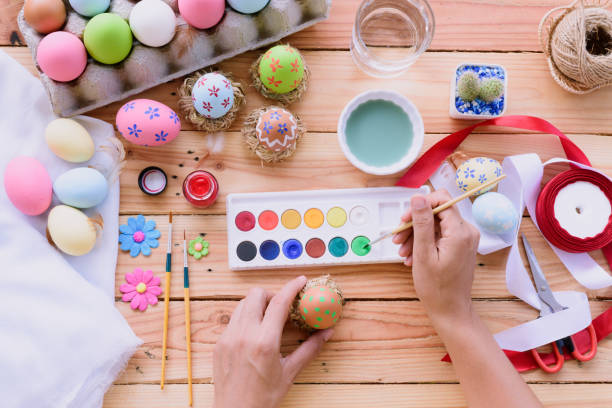istock Happy easter! A woman hand painting Easter eggs. Happy family preparing for Easter. 941442940