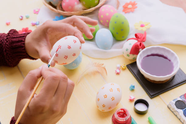 istock Happy easter! A woman hand painting Easter eggs. Happy family preparing for Easter. 941443278