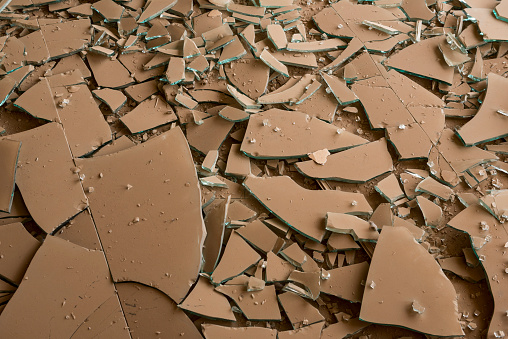 Brown dust coats the broken glass fallen on the floor of a ransacked shop in Qaraqosh, Iraq