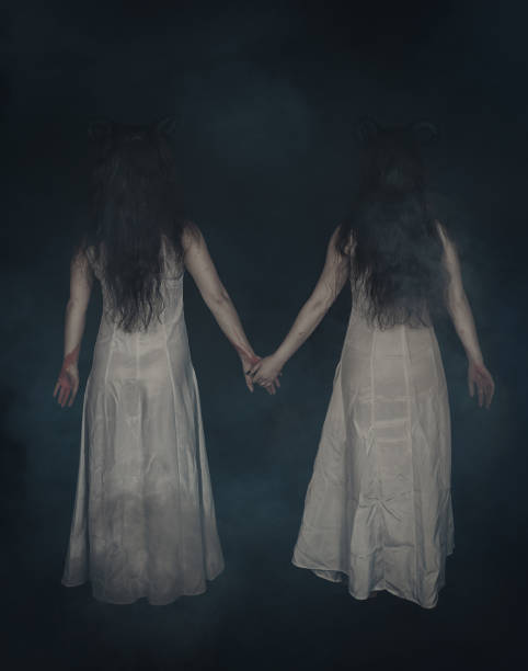 Two terrible ghost with horns on dark. Back pose stock photo