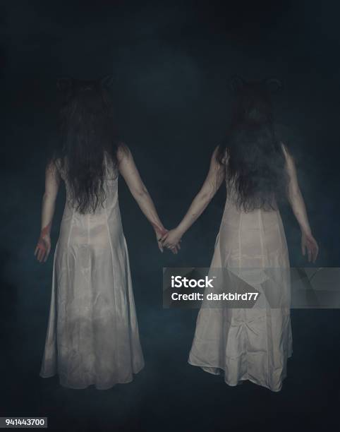 Two Terrible Ghost With Horns On Dark Back Pose Stock Photo - Download Image Now - Spooky, Twin, Girls