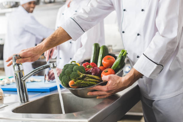 istock cropped image of chef washing vegetables at restaurant kitchen 941450554