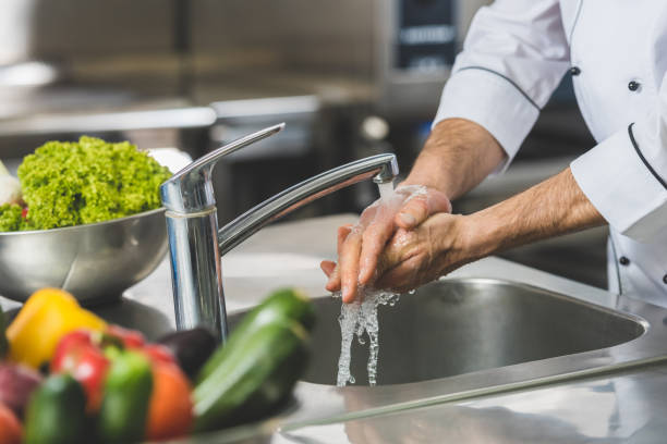 zugeschnittenes bild des küchenchefs händewaschen im restaurantküche - rohkosternährung stock-fotos und bilder