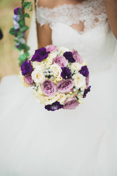 istock Bride holding big and beautiful wedding bouquet with flowers 941451098