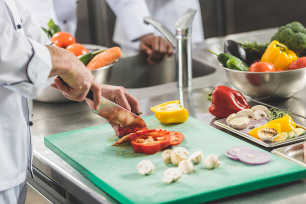 istock cropped image of chef cutting vegetables at restaurant kitchen 941451296