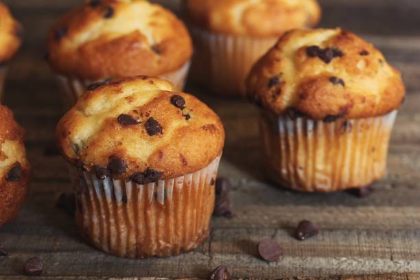 istock Mini Chocolate chip Muffins on wooden background, selective focus 941456428