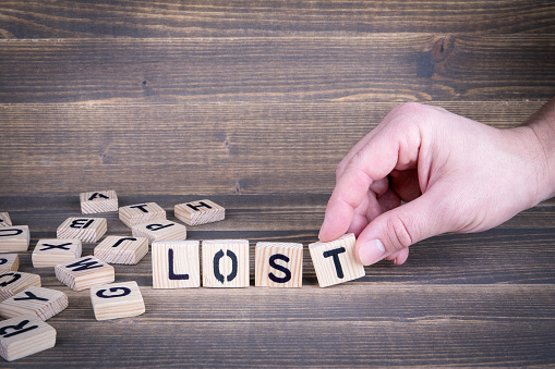 Lost. Wooden letters on the office desk, informative and communication background