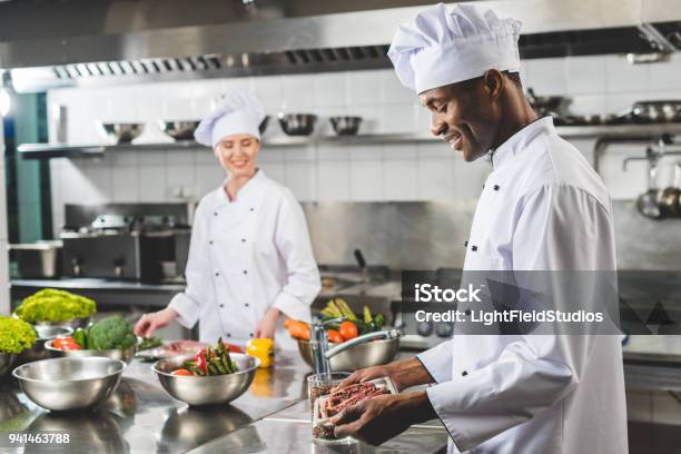 Smiling African American Chef Holding Tray With Raw Meat At Restaurant Kitchen Stock Photo - Download Image Now