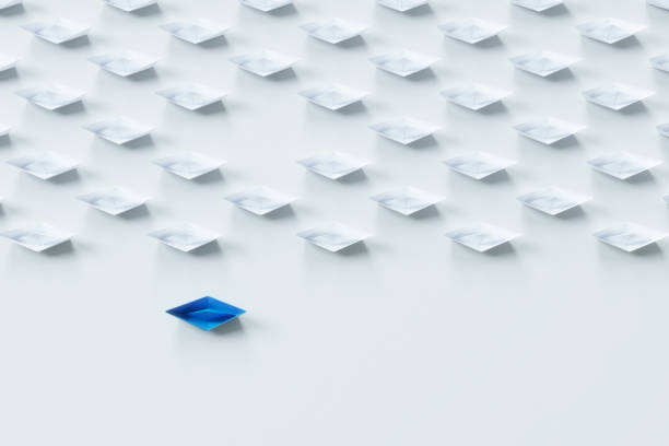 istock Leadership concept with red paper ship leading among white on white background.3d rendering. 941469998