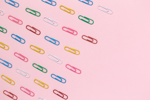 Decorative paper clips pattern on pastel pink background minimal creative concept. Space for copy.