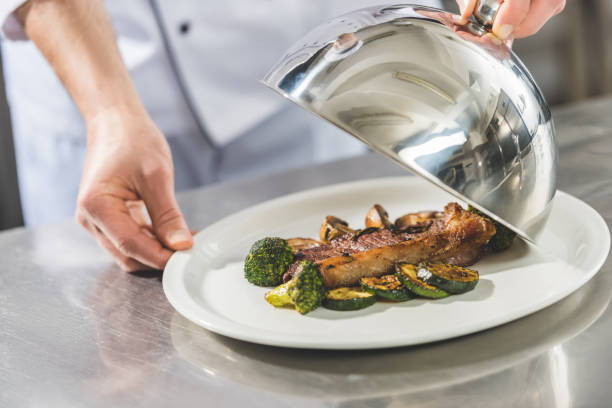 istock cropped image of chef opening plate with dish at restaurant kitchen 941470290