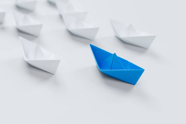 istock Leadership concept with red paper ship leading among white on white background.3d rendering. 941470430