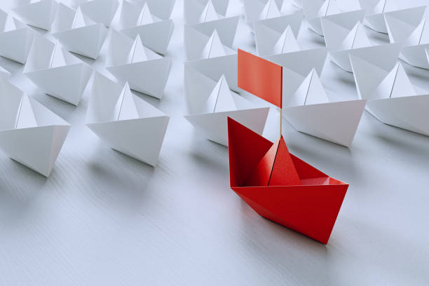 istock Leadership concept with red paper ship leading among white on white background.3d rendering. 941470648