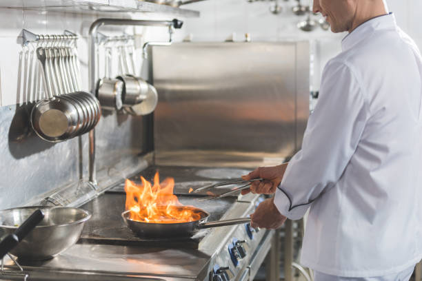istock cropped image of chef frying steak with fire at restaurant kitchen 941470926
