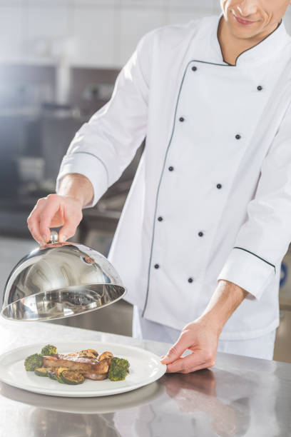istock cropped image of chef covering plate with lid at restaurant kitchen 941473474