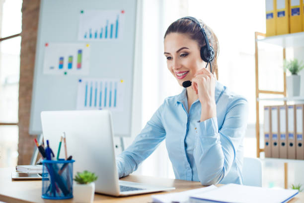portrait of young smiling happy woman in headphones working as operator of call center - speech recruitment technology young adult imagens e fotografias de stock