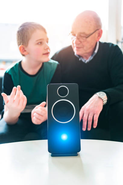 Boy teaches grandparent about how to use a digital asstant using your voice