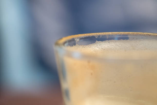 Close up of empty glass of hot coffee latte with milk foam.
