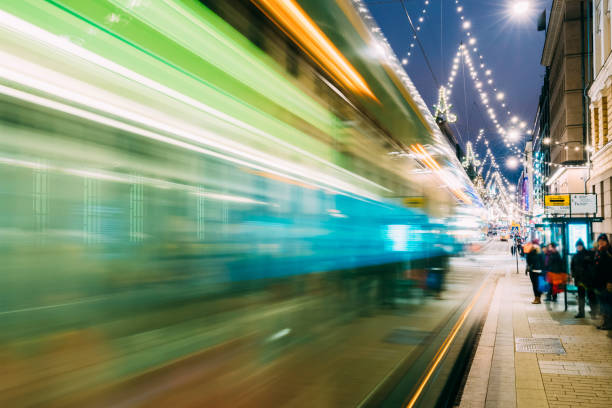 helsinki, finlandia. tramwaj odjeżdża w ruchu blur od przystanku na aleksanterinkatu ulicy w dzielnicy kluuvi w nocy wieczorem boże narodzenie boże narodzenie nowy rok świąteczne oświetlenie - blurred motion street car green zdjęcia i obrazy z banku zdjęć