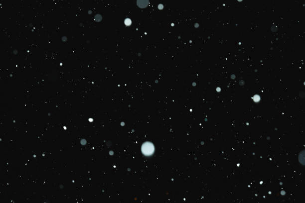istock Flakes of snow falling on a black background. Isolated 941482082