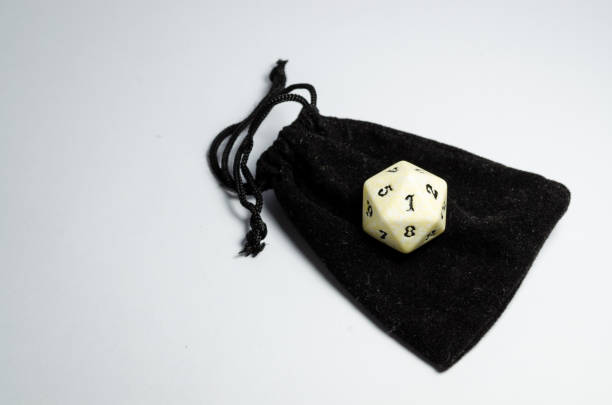 istock white twenty-sided dice on a small black purse on a white background. 941485390