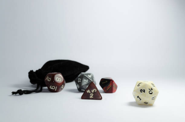 istock Dice and a small black bag, spread out in a white background. 941485430