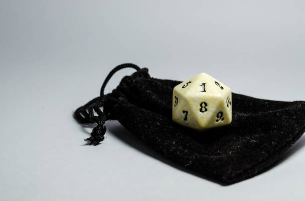 istock white twenty-sided dice on a small black purse on a white background. 941485464