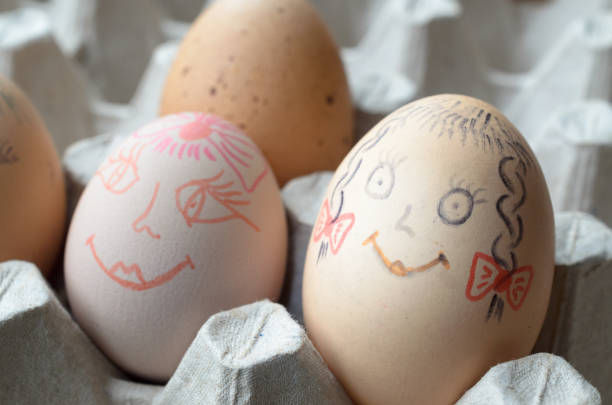 istock Eggs with painted merry muzzles in the tray. 941488282