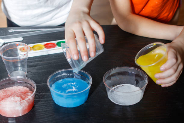 crianças fazem experimentos com tinta e neve artificial - colors liquid small laboratory - fotografias e filmes do acervo