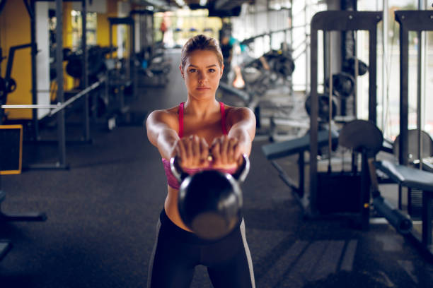 istock Young woman doing kettlebell exercise at gym 941495322