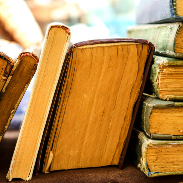 istock Old antiquarian books stand horizontally in a row. Front view. Selective focus. 941495892